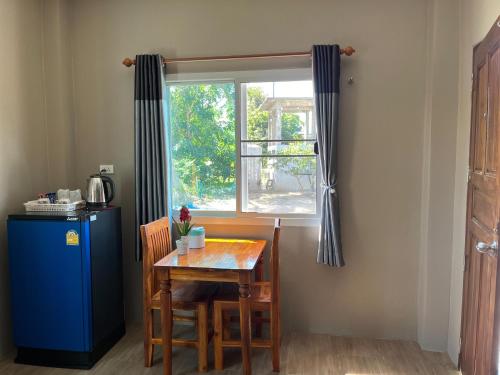 une table et des chaises et une fenêtre dans une pièce dans l'établissement Greathill Gardenhome Resort Chomthong-Chiangmai, à Chom Thong