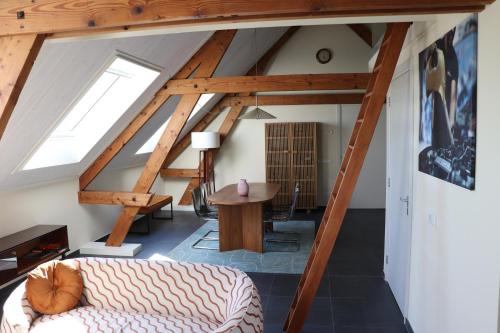 an attic room with a couch and a table at WijkD in Leende