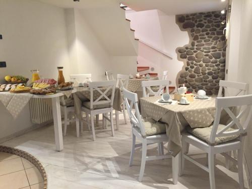 une salle à manger avec une table, des chaises et de la nourriture. dans l'établissement B&B Rosso Pila, à Trente