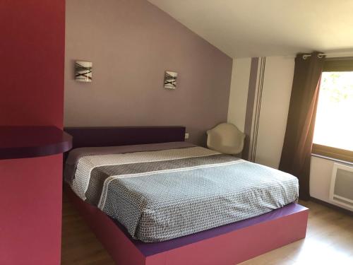 une chambre avec un lit et une fenêtre dans l'établissement Charmant logement, à Saint-Amand-de-Vergt