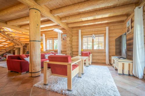 a living room with red chairs and a wooden ceiling at Lomnický Zrub in Veľká Lomnica
