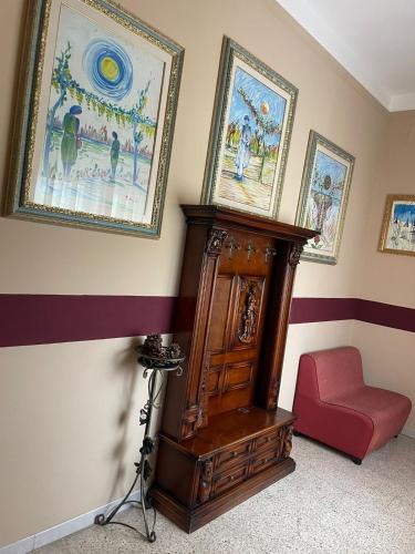 a room with a wooden cabinet and paintings on the wall at Hotel Bed & Breakfast Minu' in Paravati
