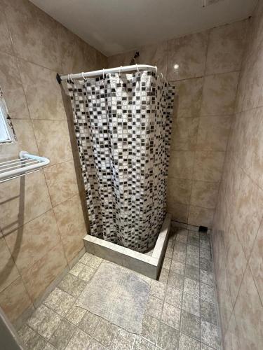 a shower with a shower curtain in a bathroom at Hotel Paris in Río Gallegos