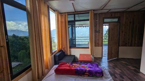 a bedroom with a bed in a room with windows at Munsong Norling Homestay - A unit of Dhitang- Offbeat Kalimpong in Pedong