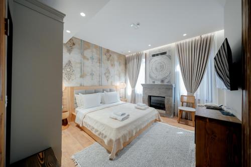 een slaapkamer met een groot bed en een open haard bij Vintage Boutique Hotel in Korçë