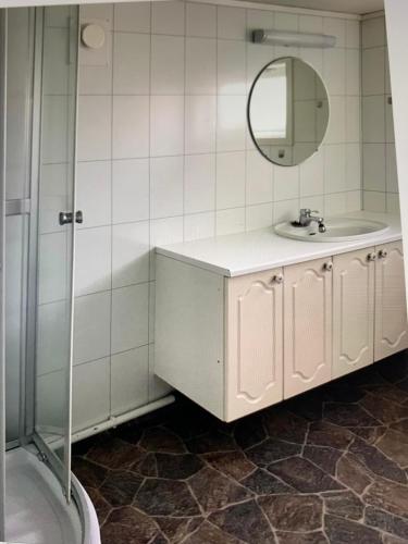 a white bathroom with a sink and a mirror at Sentrumsnær kjellerleilighet, nær sykehus og høgskole, parkering in Haugesund