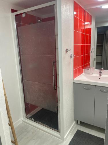 une douche avec une porte vitrée dans une salle de bain dans l'établissement Studio meublé, à Saint-Jean-de-Védas