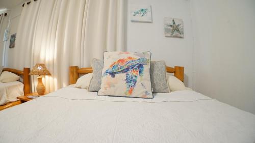 a white bed with a pillow on top of it at Villas Welcome to Heaven in Carrillo