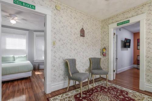 a bedroom with a bed and two chairs and a mirror at The Big House in Jefferson City