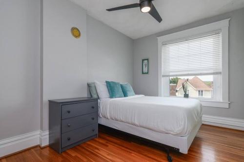 a bedroom with a bed with a ceiling fan and a window at The Big House in Jefferson City