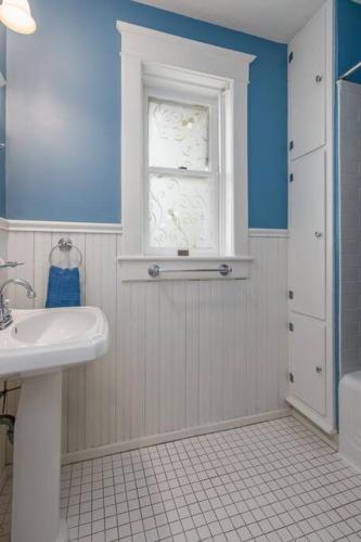 a bathroom with a white sink and a window at The Big House in Jefferson City