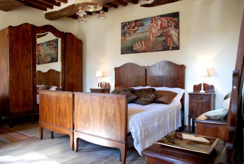 a bedroom with a bed with a wooden headboard and a mirror at Casale Olea in Massarosa