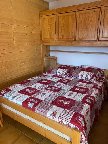 une chambre avec un lit avec une couette dessus dans l'établissement Appartement avec balcon à Praz-sur-Arly 40 m² vue montagne, à Praz-sur-Arly
