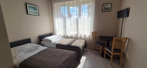 a hotel room with two beds and a window at Sejf House in Gdańsk