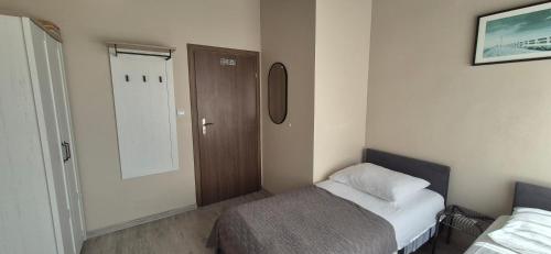a small room with a bed and a door at Sejf House in Gdańsk