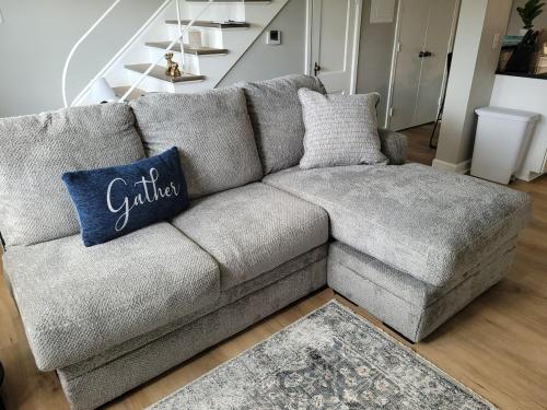 a gray couch with a blue pillow on it at Davenport Dwellings 2 Bd by UNMC in Omaha