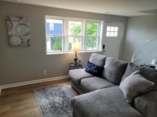 a living room with a couch and two windows at Davenport Dwellings 2 Bd by UNMC in Omaha