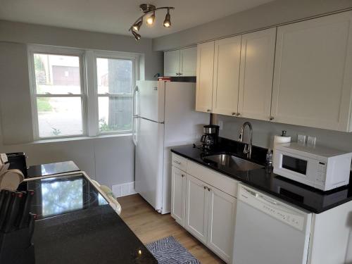 a kitchen with a white refrigerator and a sink at Davenport Dwellings 2 Bd by UNMC in Omaha