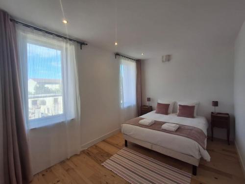 a white bedroom with a bed and a window at Evasions-Dérobade, centre-ville, gare in Auterive