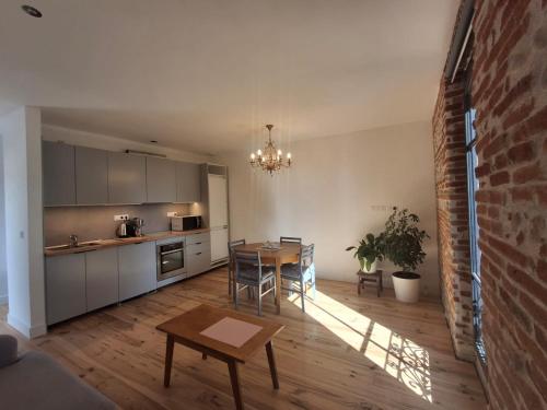 une cuisine avec une table et une salle à manger dans l'établissement Evasions-Dérobade, centre-ville, gare, à Auterive