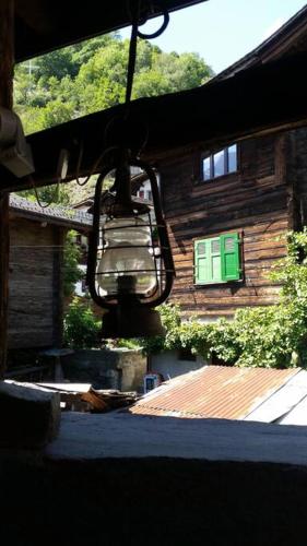 a house with a light hanging from a building at Historische Maisonettewohnung bis 10 Gäste, Magic Pass Belalp, Rosswald und mehr in Naters