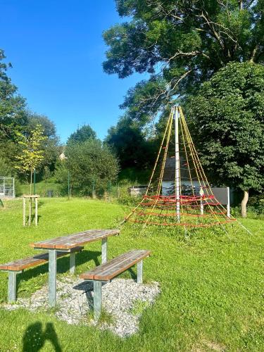 a park with two benches and a play structure at Penzion Krumlovské rozcestí in Český Krumlov