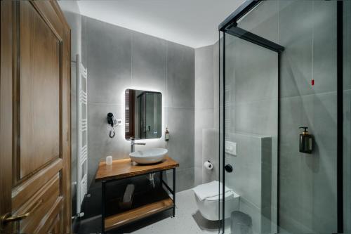 een badkamer met een wastafel, een toilet en een douche bij Vintage Boutique Hotel in Korçë