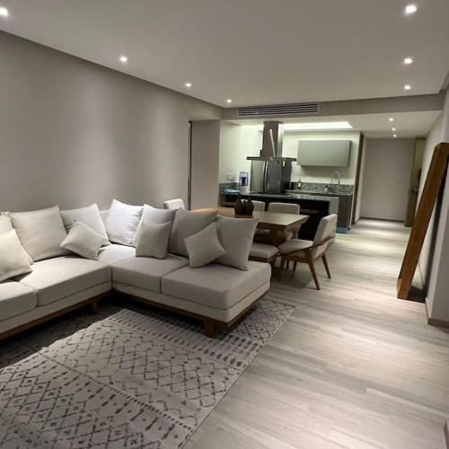 a living room with a white couch and a table at MAR DEL RIO - Torre Península - Playa privada in Conchal