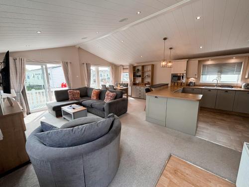 a living room with two couches and a kitchen at 2 Lakeside, Luxury lodge with private garden & parking in Patrington
