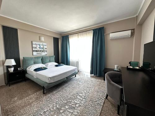 a hotel room with a bed and a window at Vila Aquamarine in Eforie Nord