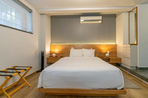 a bedroom with a large white bed and a window at La Campechana in the heart of Roma and Condesa in Mexico City
