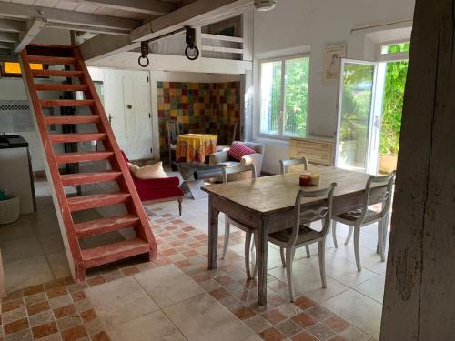 un salon avec une table et des chaises en bois dans l'établissement Le Tapis Vert - Loft avec jardin, à Auch