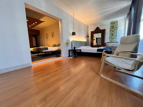 a room with two beds and two chairs in it at Castilho 63 Hostel & Suites in Lisbon