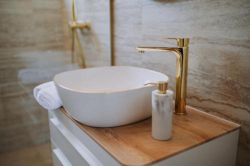 a bathroom with a white sink and a gold faucet at Villa Mars in Mandre