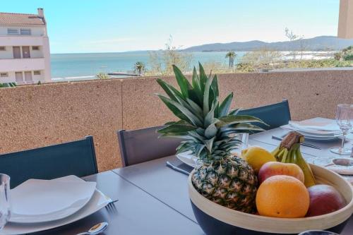 - un bol de fruits sur une table avec vue dans l'établissement Duplex front de mer, à Fréjus