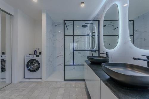 une salle de bain avec deux lavabos et une machine à laver dans l'établissement Duplex front de mer, à Fréjus