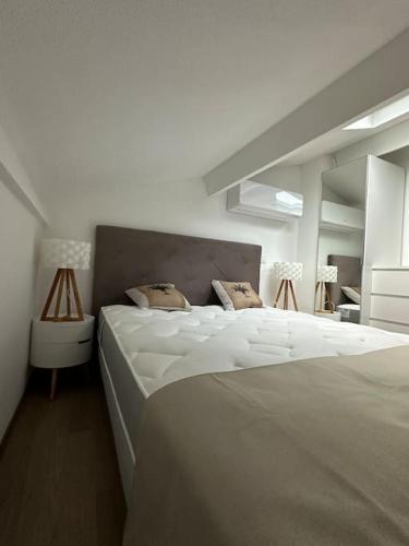 - une chambre blanche avec un grand lit blanc et 2 oreillers dans l'établissement Duplex front de mer, à Fréjus