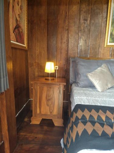 a bedroom with a bed and a lamp on a night stand at Bujak Permai Villa Matahari Lombok NTB in Praya