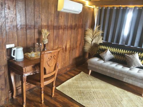 a room with a desk and a couch and a table with a chair at Bujak Permai Villa Matahari Lombok NTB in Praya