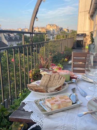 une table avec des assiettes de nourriture sur un balcon dans l'établissement Grand appartement familial Parisien, avec balcon et parking, à Paris