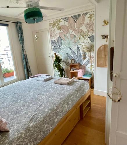 une chambre avec un lit avec un papier peint fleuri dans l'établissement Grand appartement familial Parisien, avec balcon et parking, à Paris
