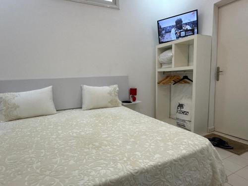 a bedroom with a bed with a tv on the wall at Bouba in Dakar