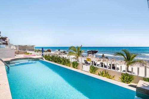 a swimming pool with the beach in the background at Villas Najo' Isla Mujeres. in Isla Mujeres