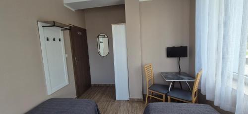a room with two beds and a table and a mirror at Sejf House in Gdańsk