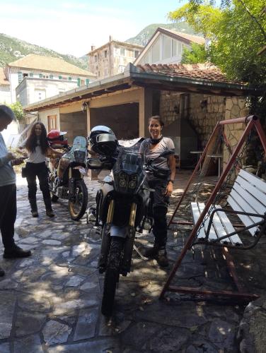 a man is standing next to a motorcycle at Apartments Montenegro Risan Čučković in Risan