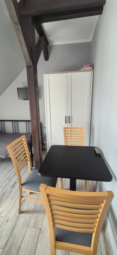a black table and chairs in a room at Sejf House in Gdańsk