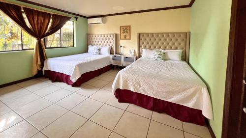 een slaapkamer met twee bedden en een raam bij Villa Noelia in El Jurón