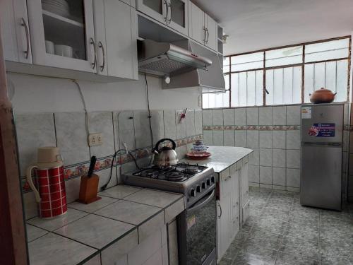 a kitchen with a stove and a refrigerator at Pawllu Inqa Lodge in Cusco
