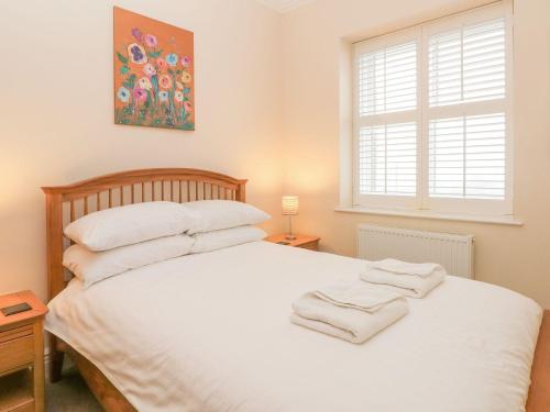 una camera da letto con un grande letto bianco con asciugamani sopra di 12 Eagle Parade a Buxton
