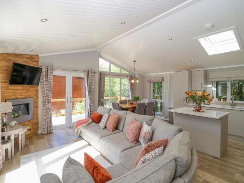 a living room with a couch and a kitchen at Waterside Lodge in Windermere